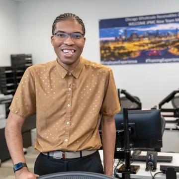 A smiling Bridges participant at his office job